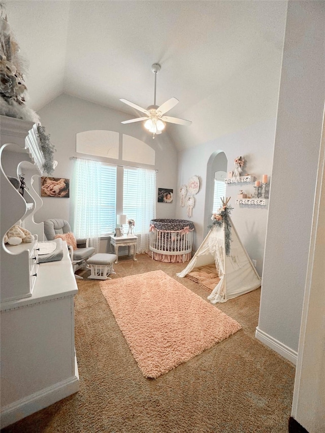 carpeted bedroom featuring vaulted ceiling, arched walkways, a ceiling fan, and baseboards