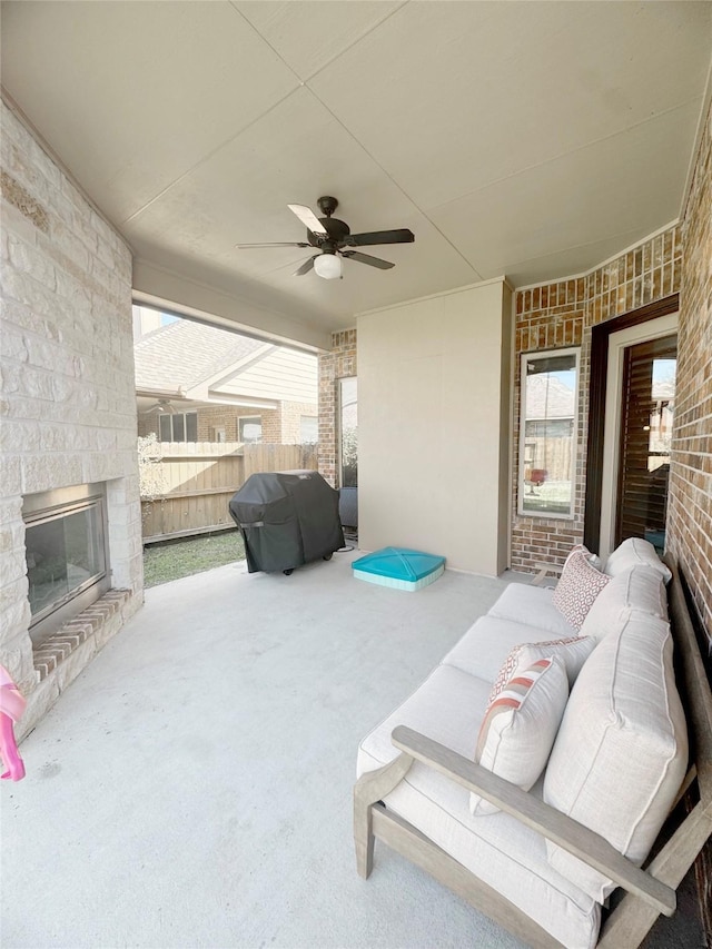 view of patio / terrace featuring an outdoor living space with a fireplace, a grill, fence, and ceiling fan