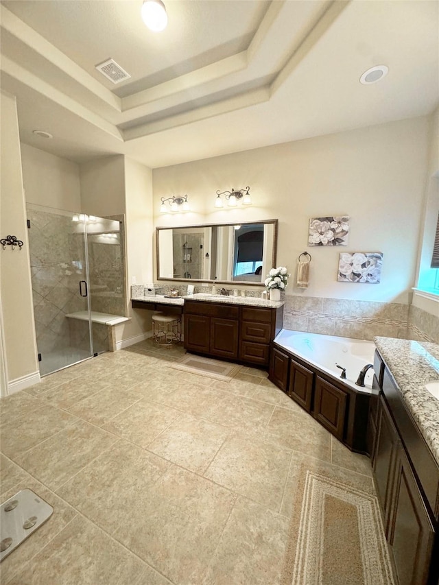 bathroom with vanity, visible vents, a shower stall, a bath, and a tray ceiling