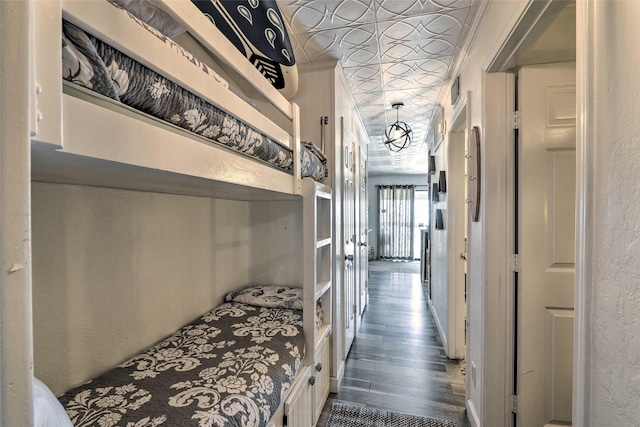 bedroom with an ornate ceiling, wood finished floors, and a textured wall