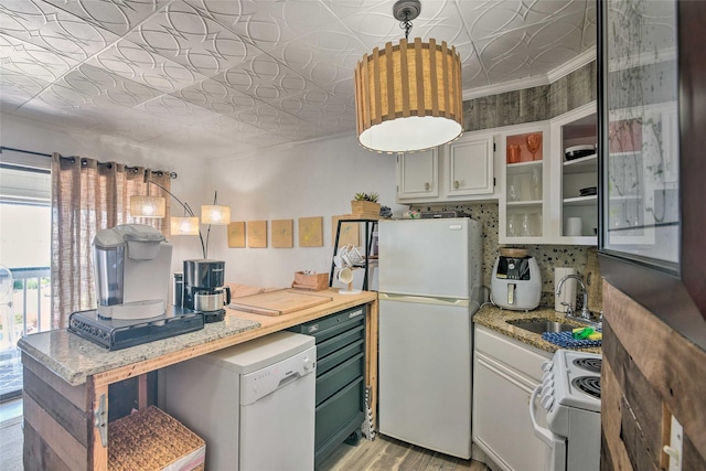 kitchen featuring an ornate ceiling, light wood finished floors, backsplash, a sink, and white appliances