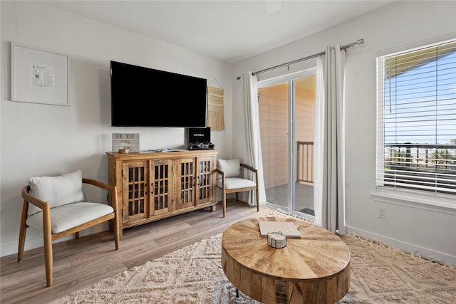 living area with baseboards and wood finished floors