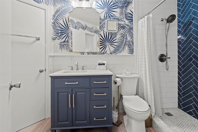 bathroom featuring wood finished floors, a stall shower, vanity, and toilet