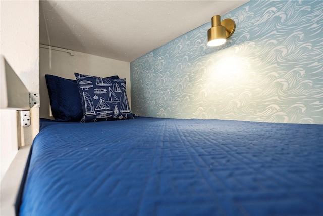 unfurnished bedroom featuring wallpapered walls and a textured ceiling