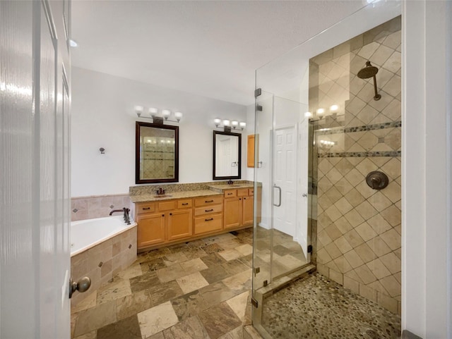 full bathroom featuring a sink, a stall shower, and a garden tub