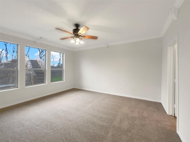 carpeted spare room featuring visible vents, ornamental molding, a ceiling fan, and baseboards