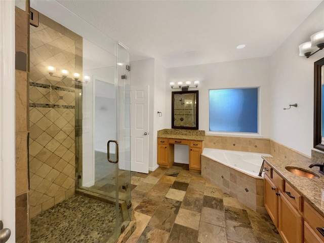 bathroom featuring stone finish floor, a garden tub, a shower stall, and vanity