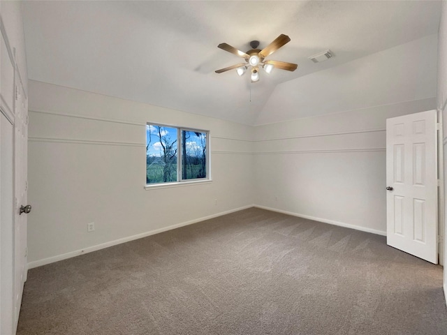 unfurnished room featuring lofted ceiling, visible vents, a ceiling fan, carpet flooring, and baseboards