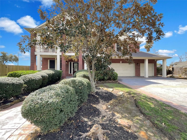 obstructed view of property with a balcony, an attached garage, fence, and brick siding