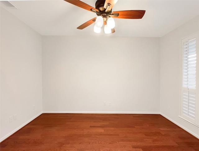 spare room with visible vents, baseboards, and wood finished floors