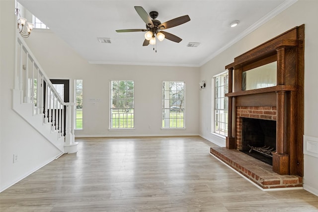 unfurnished living room featuring visible vents, stairway, ornamental molding, a fireplace, and light wood-style floors