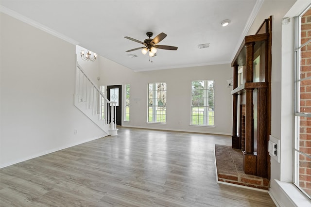 unfurnished living room with visible vents, ceiling fan with notable chandelier, stairs, and ornamental molding