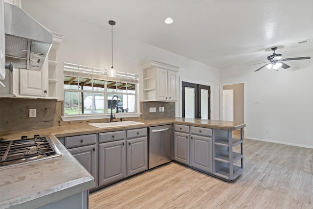 kitchen with gray cabinetry, stainless steel appliances, a peninsula, and open shelves