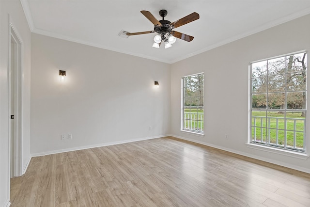 spare room featuring light wood finished floors, visible vents, crown molding, baseboards, and ceiling fan