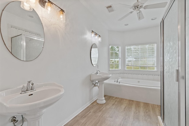 bathroom featuring wood finished floors, visible vents, ceiling fan, a shower stall, and a bath