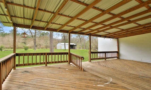 deck featuring a lawn, a storage unit, and an outdoor structure