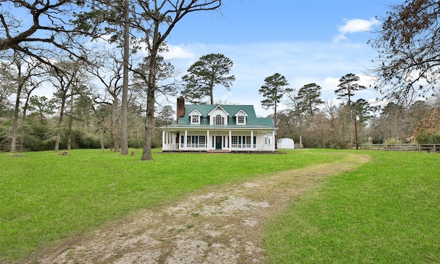 view of front of property with a front lawn, fence, covered porch, an outbuilding, and driveway