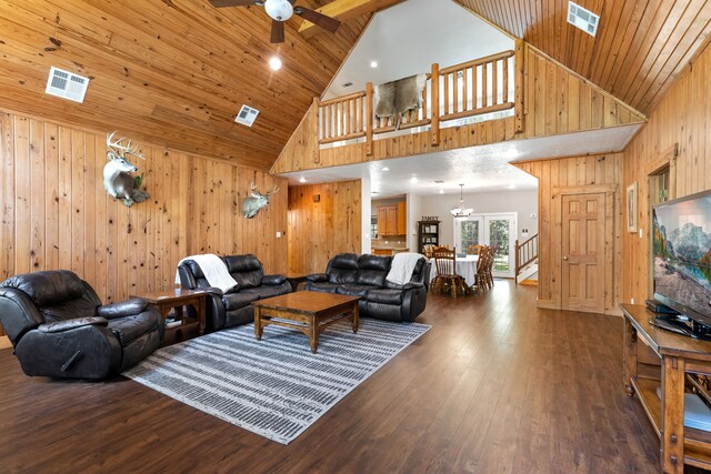 living area with visible vents, wooden walls, and hardwood / wood-style flooring