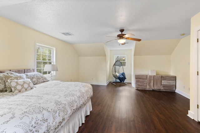 bedroom featuring visible vents, dark wood-type flooring, ceiling fan, baseboards, and vaulted ceiling