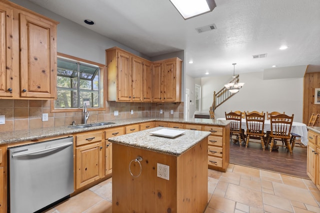 kitchen with a peninsula, a sink, dishwasher, tasteful backsplash, and a center island