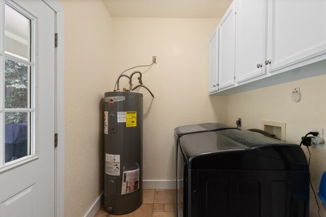 laundry room featuring baseboards, cabinet space, electric water heater, and independent washer and dryer
