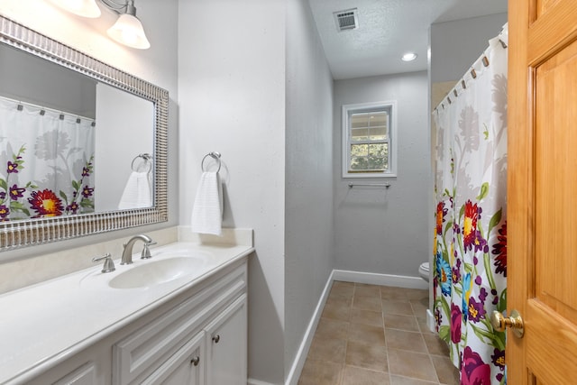 full bathroom featuring visible vents, baseboards, toilet, vanity, and a textured ceiling