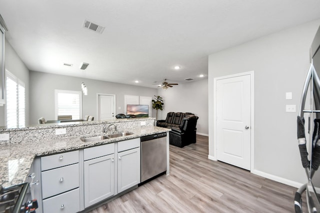 kitchen with visible vents, stainless steel dishwasher, light wood-style floors, a sink, and range