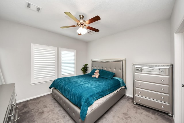 carpeted bedroom with a ceiling fan, visible vents, and baseboards