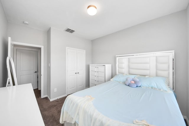 bedroom featuring baseboards, visible vents, dark carpet, and a closet