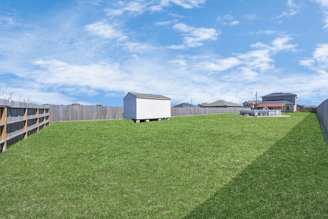 view of yard with a storage unit, an outdoor structure, and a fenced backyard