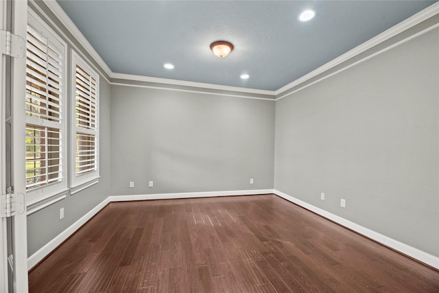 empty room featuring crown molding, baseboards, wood finished floors, and recessed lighting