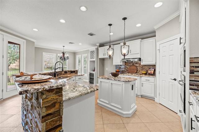 kitchen with a spacious island, crown molding, wine cooler, and a sink