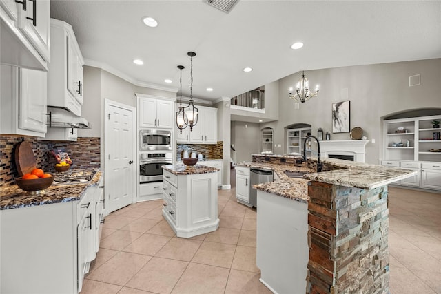 kitchen featuring a notable chandelier, appliances with stainless steel finishes, light tile patterned flooring, a sink, and a large island with sink