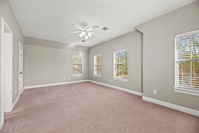 unfurnished room featuring light carpet, ceiling fan, visible vents, and baseboards