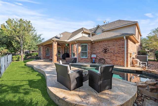 back of house featuring brick siding, a patio area, a fenced backyard, and a jacuzzi