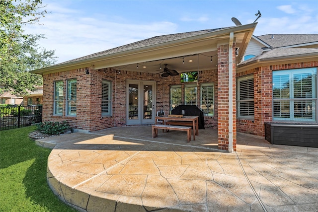 rear view of house with french doors, brick siding, a patio, ceiling fan, and fence