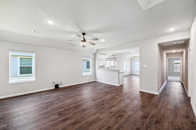 unfurnished living room featuring baseboards, visible vents, dark wood-style flooring, and ceiling fan