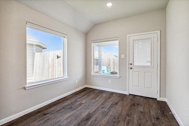 interior space with vaulted ceiling, dark wood-style floors, and baseboards