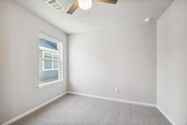 unfurnished room with visible vents, light carpet, baseboards, and a ceiling fan