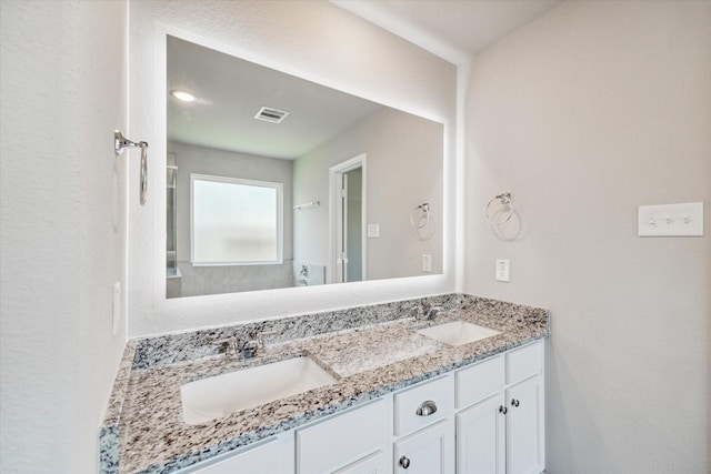 bathroom featuring double vanity, visible vents, and a sink