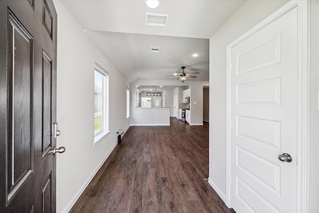 foyer entrance with visible vents, baseboards, ceiling fan, and dark wood-style flooring