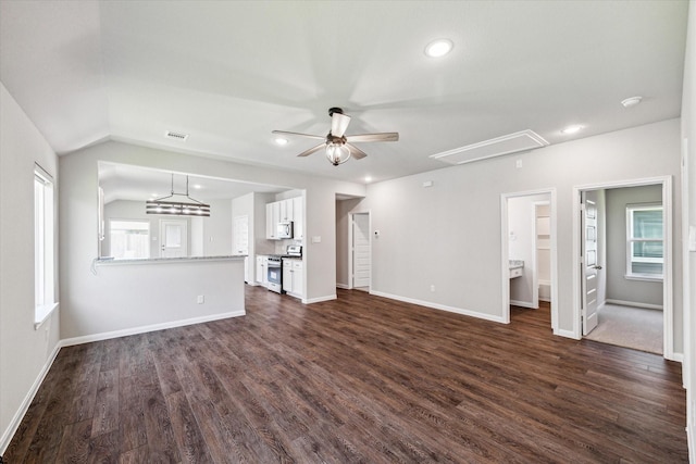 unfurnished living room featuring dark wood finished floors, attic access, a ceiling fan, and lofted ceiling