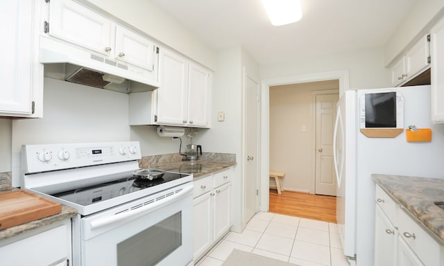 kitchen featuring light tile patterned floors, light stone counters, under cabinet range hood, white appliances, and white cabinetry