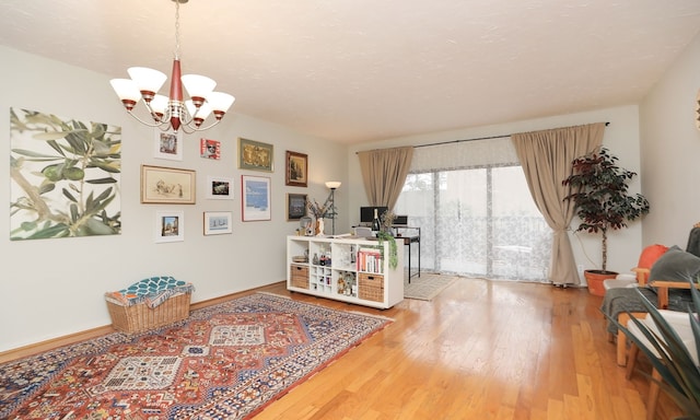 living area featuring a chandelier, baseboards, and wood finished floors