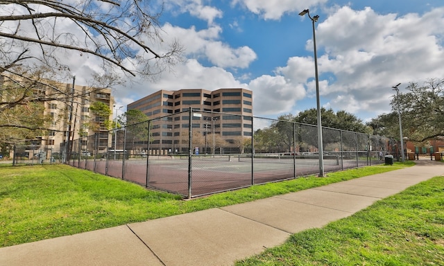 view of sport court featuring fence and a yard