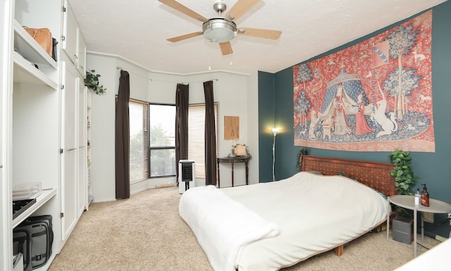 bedroom with a textured ceiling, a ceiling fan, and light colored carpet