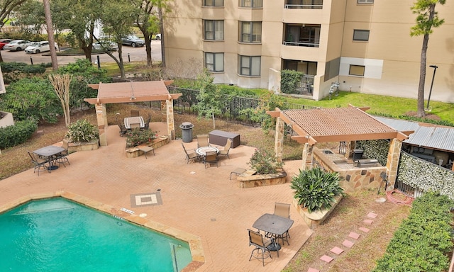 pool featuring fence, outdoor dry bar, and a patio