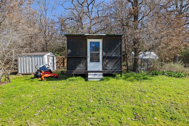 view of greenhouse with a storage unit and a lawn