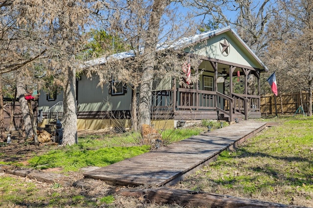 view of front facade with a porch, a front yard, and fence