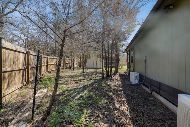 view of yard with ac unit, a fenced backyard, a shed, and an outdoor structure